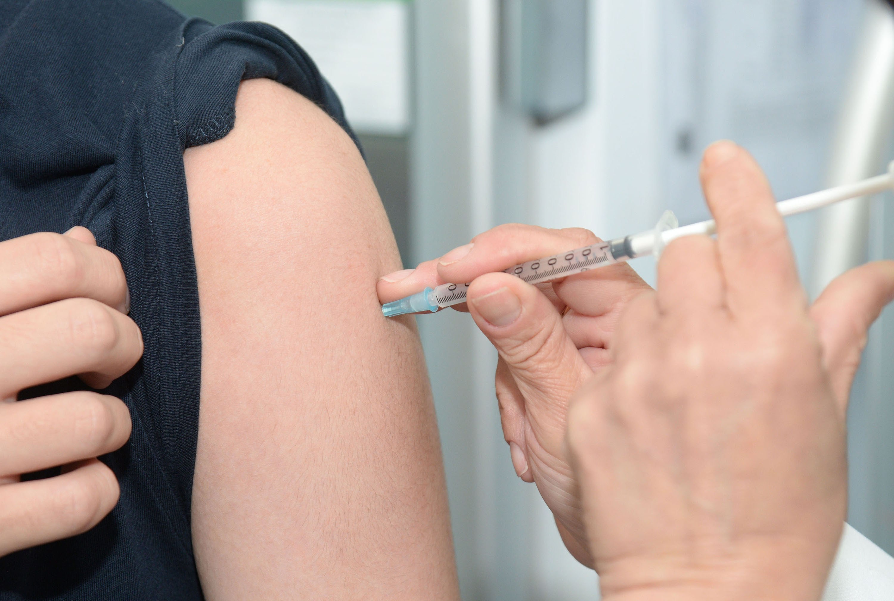 A Vaccine Being Administered Into A Patient's Arm