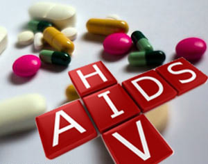 Picture Of Various Pills And Letter Tiles Spelling Out HIV And AIDS