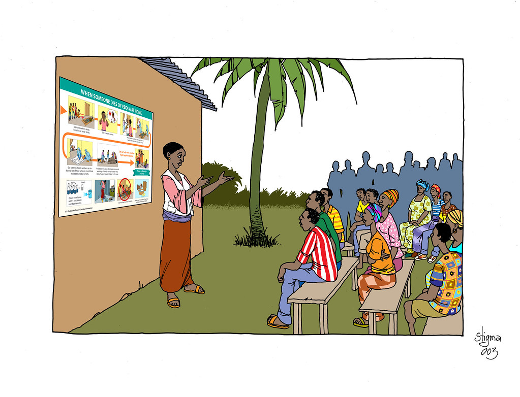 A Cartoon Of A Woman Teaching A Class About Ebola. All The Figures In The Picture Are Adult Africans Sitting On Benches And Wearing A Variety Of Clothing, Including Some Traditional Outfits. The Teacher Is Using A Poster Taped To The Side Of A Building. There Is A Palm Tree In The Center.