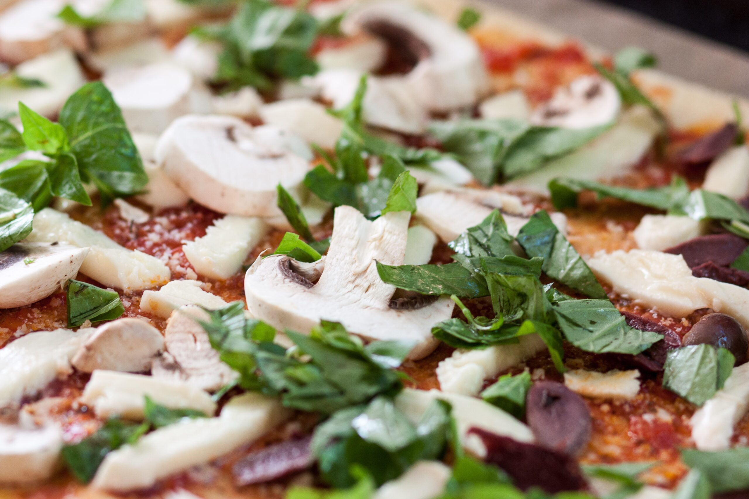 Close Up Picture Of A Pizza With Mushrooms And Fresh Herbs