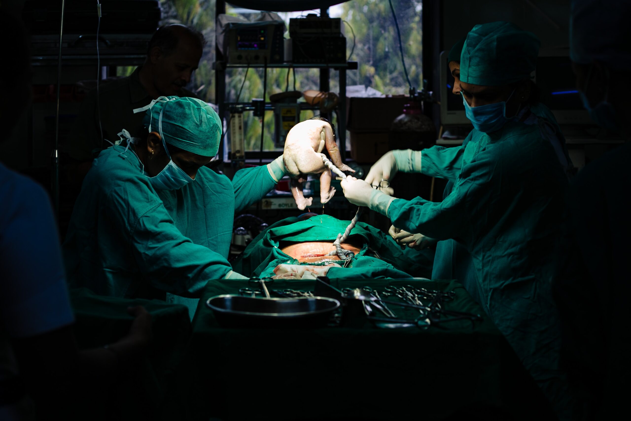 Image Of Baby Being Born In Operating Room By C-section.