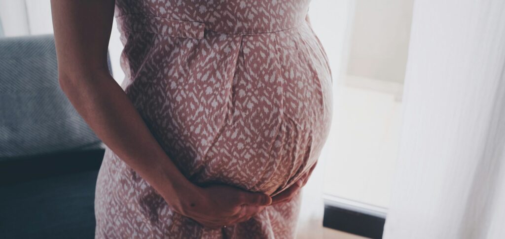 a pregnant person holding their belly