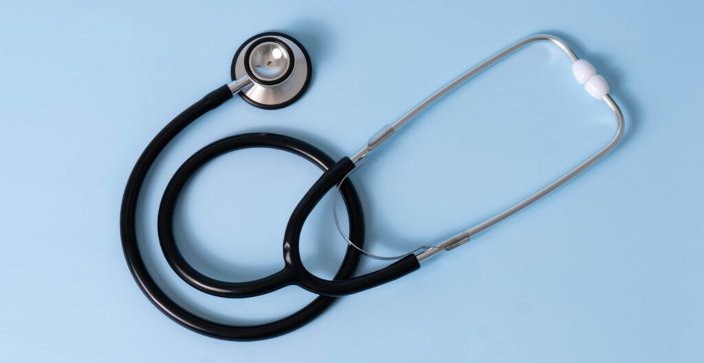 Simple stethoscope on a pastel blue background.