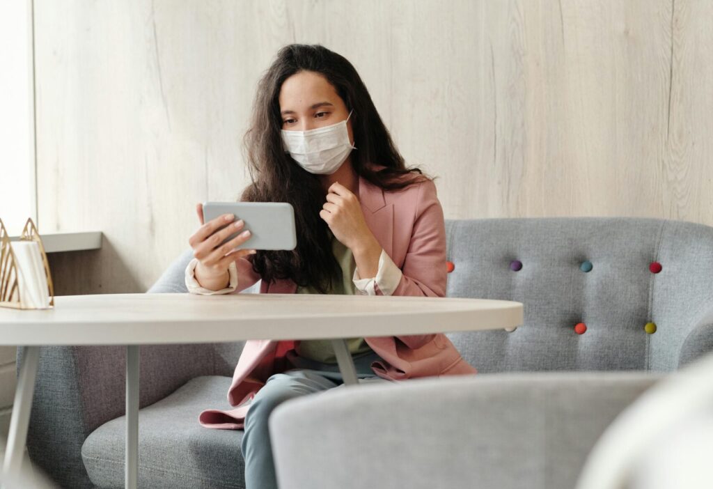 Woman Wearing A Face Mask While Sitted Using Her Phone